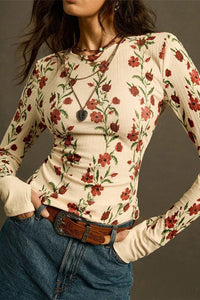 Woman wearing a floral long-sleeve top with a neutral background