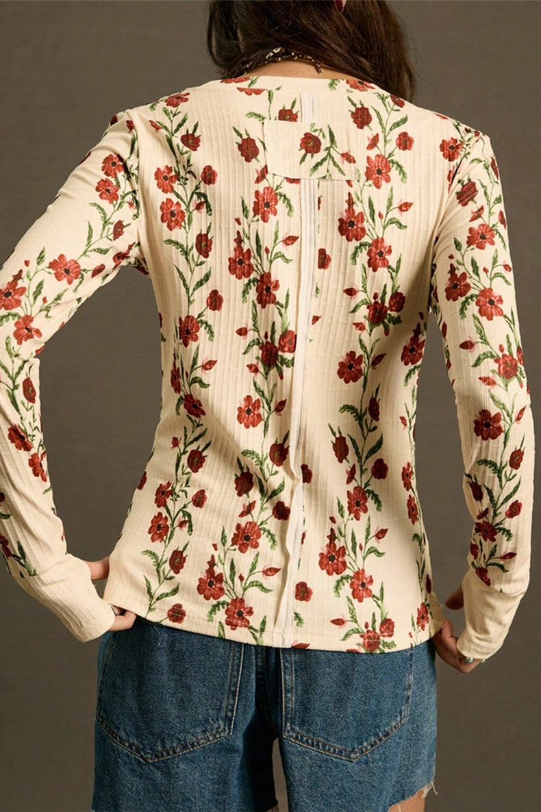 Floral patterned top worn by a person against a neutral background