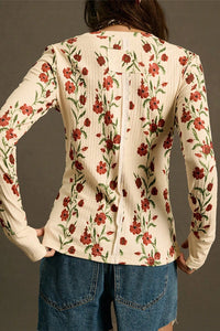 Floral patterned top worn by a person against a neutral background